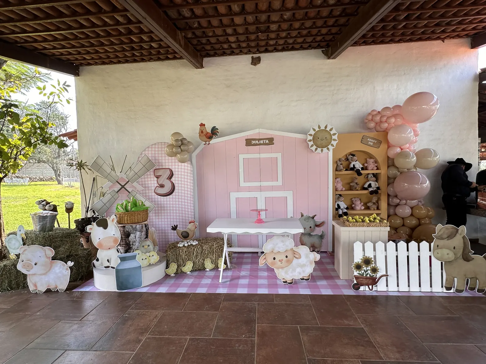 Decoración de granja con animalitos, globos rosas y mesa infantil
