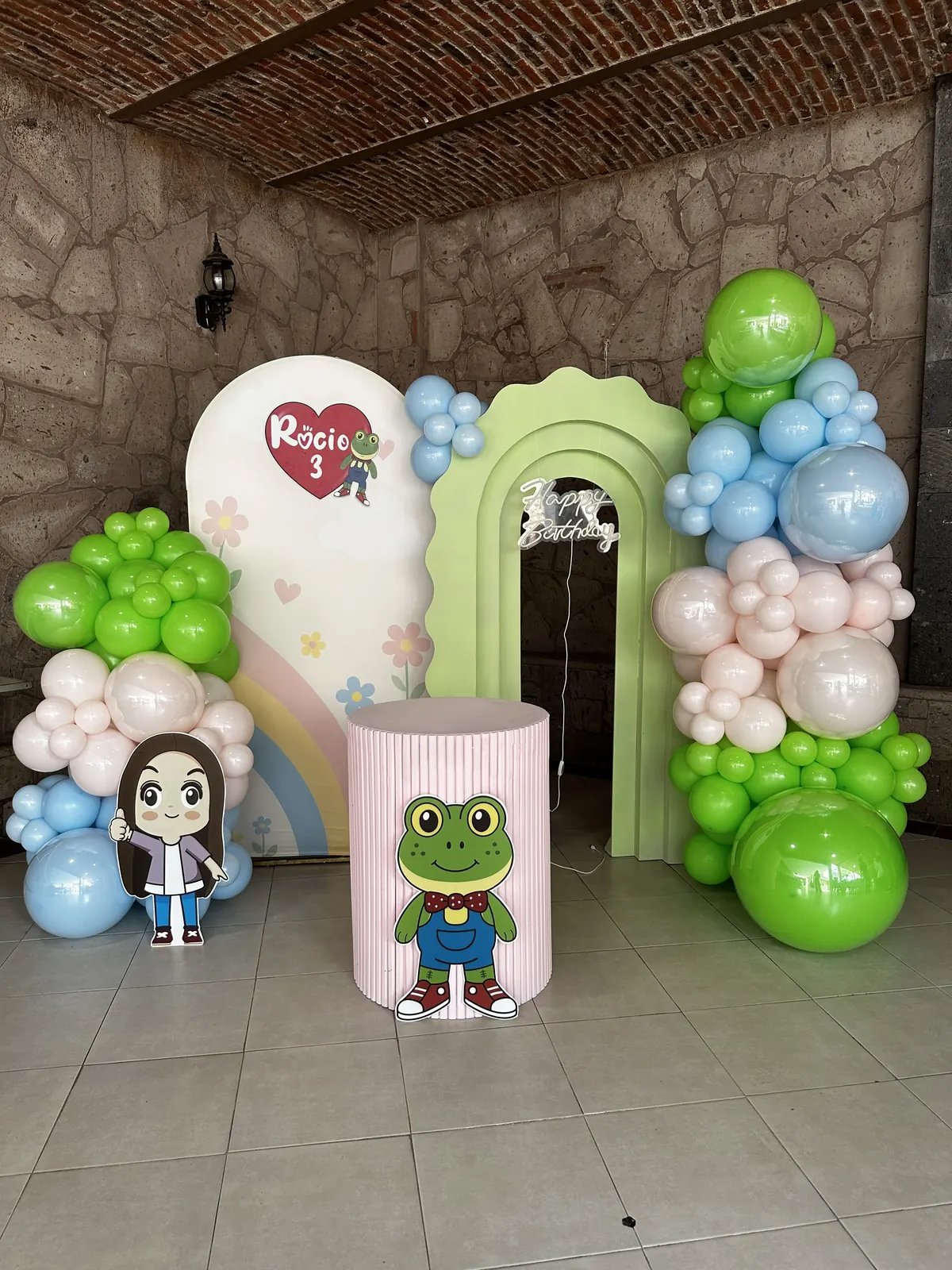 Arco de globos verdes, azules y rosas con personajes temáticos